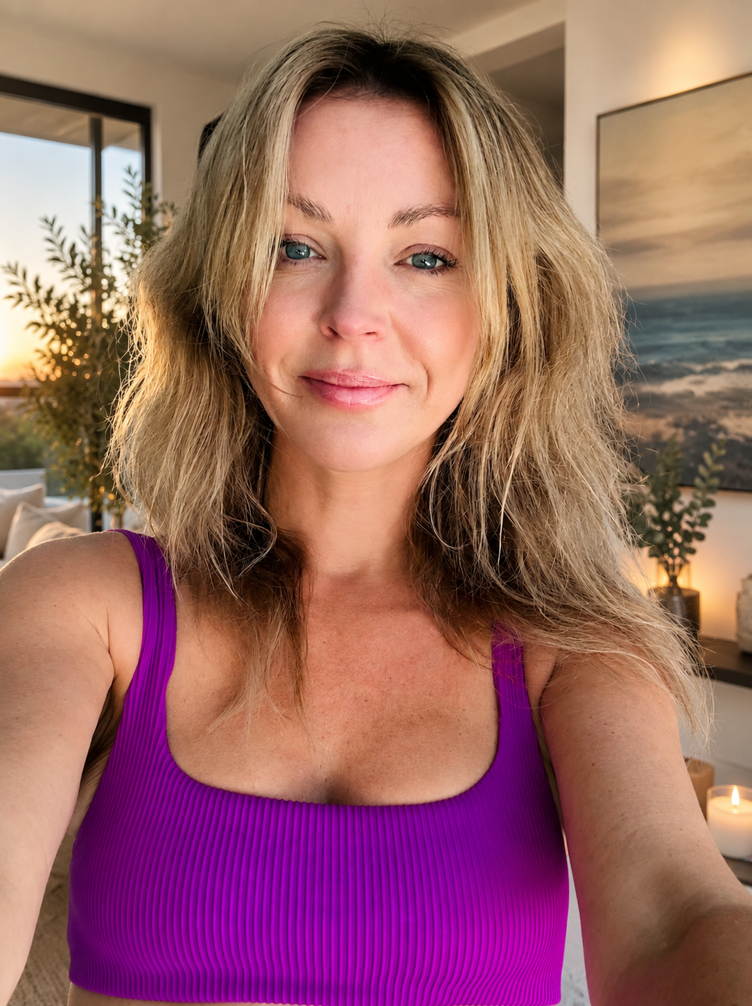 Woman wearing a purple tank top indoors with a scenic view in the background